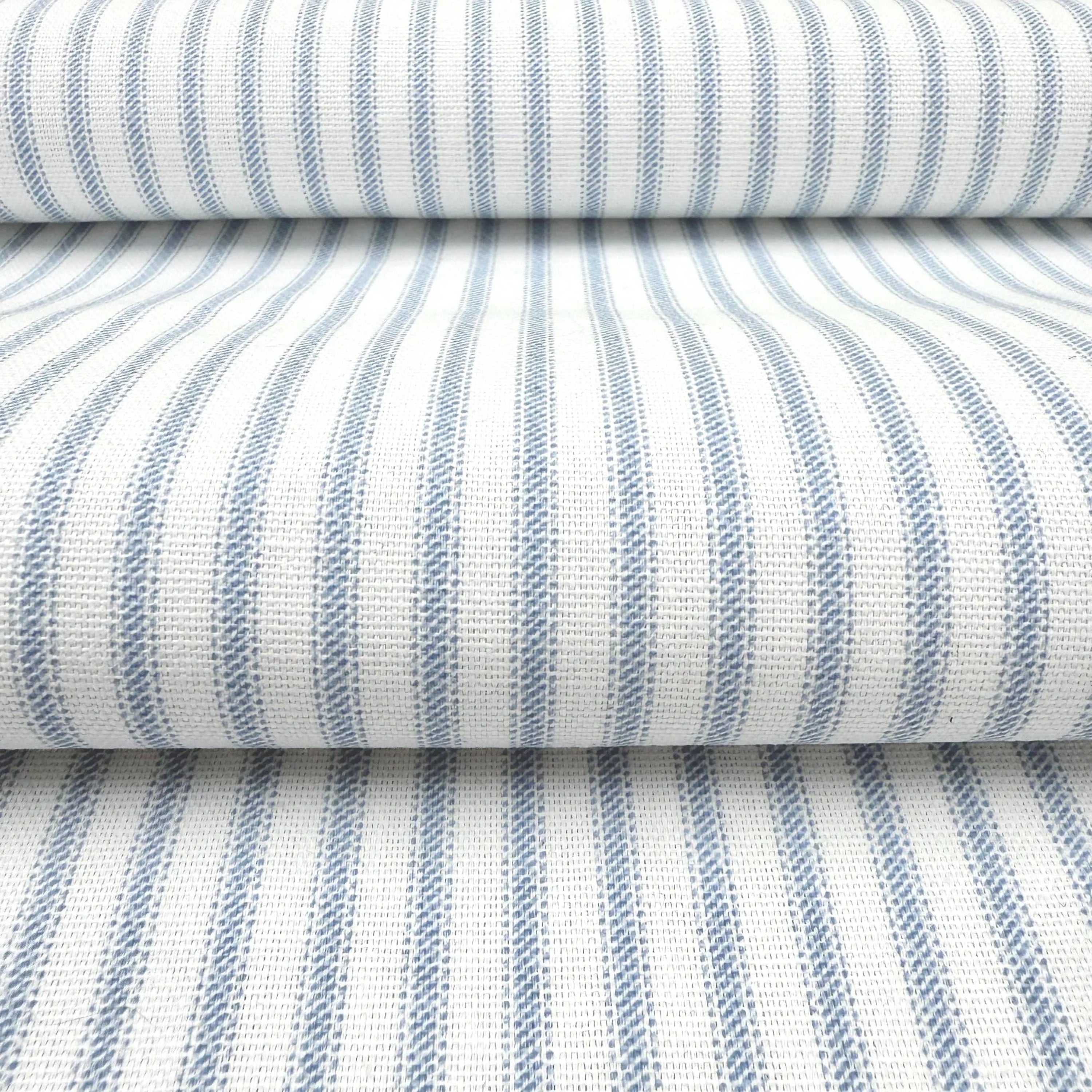a close-up view of a fabric with a striped pattern in shades of blue and white. The fabric appears to be folded or rolled up, creating a layered effect.