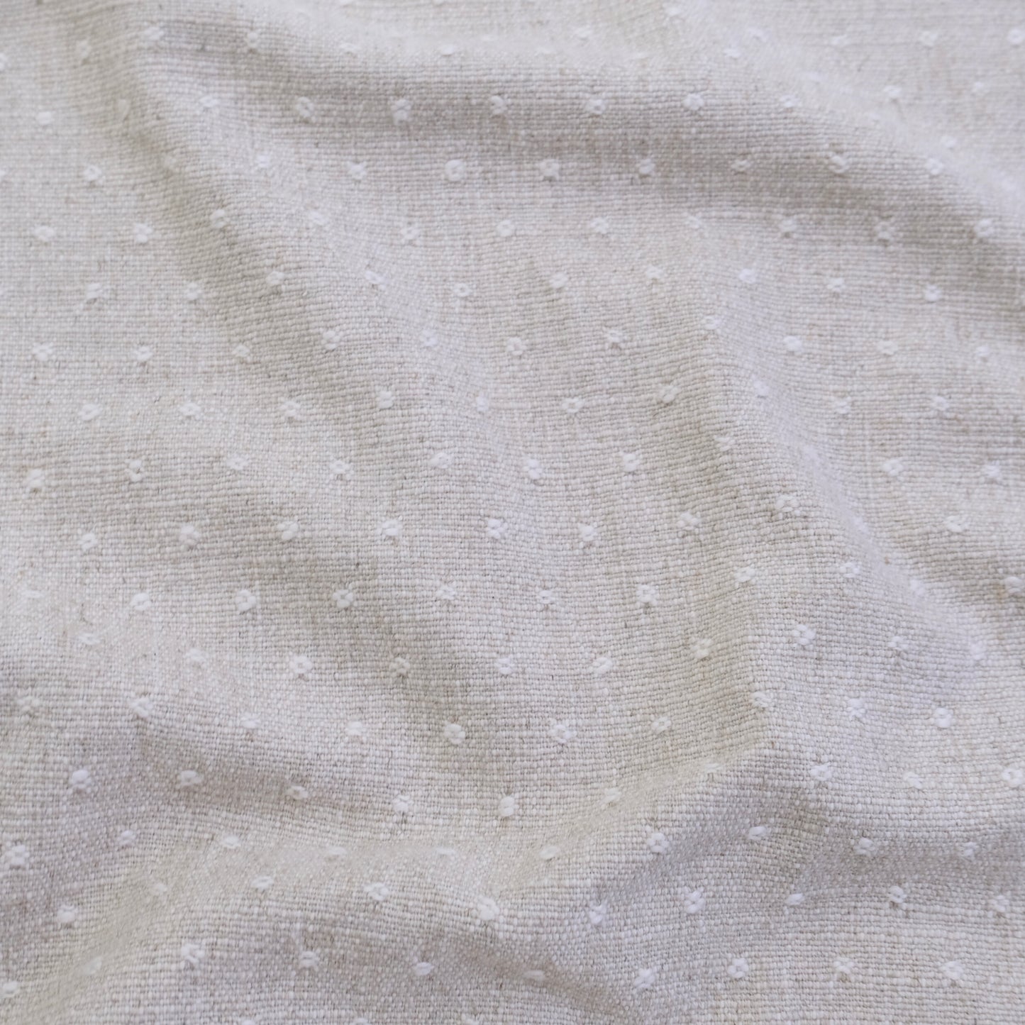 a close-up view of a fabric with small white dots or polka dots, creating a textured and patterned appearance.