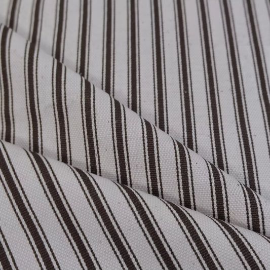 A close-up view of a fabric with a striped pattern in shades of white and brown.