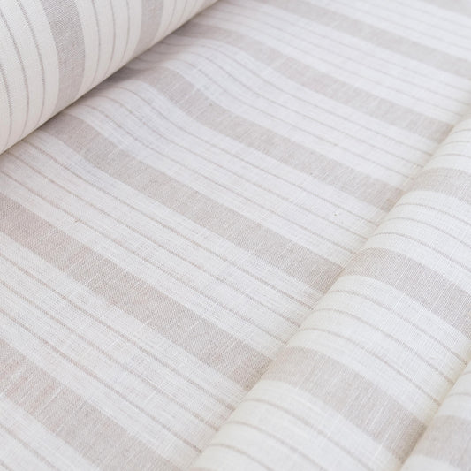 Roll of taupe stripe linen fabric neatly displayed to show stripe repetition, texture, and soft neutral taupe tones. Great for rustic farmhouse curtains, neutral cottage décor, and DIY sewing projects like placemats, runners, and table linens. This fabric combines the durability of linen with a light airy hand, making it perfect for sewing lightweight home décor pieces with a timeless stripe design.