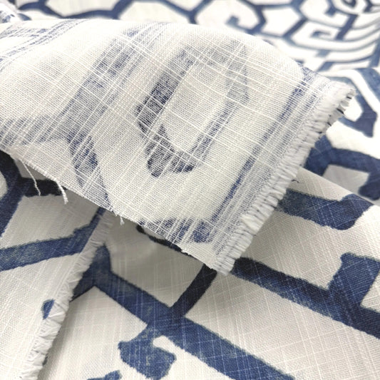a close-up view of a fabric with a blue and white geometric pattern. The fabric appears to be made of a soft, textured material, possibly cotton or linen. The pattern consists of various shades of blue and white, creating a visually striking and intricate design.