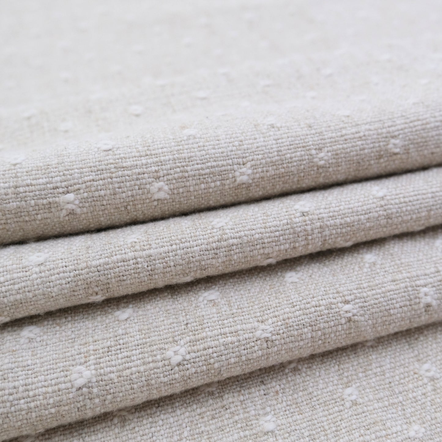A close-up view of a folded fabric with a textured, beige-colored appearance.