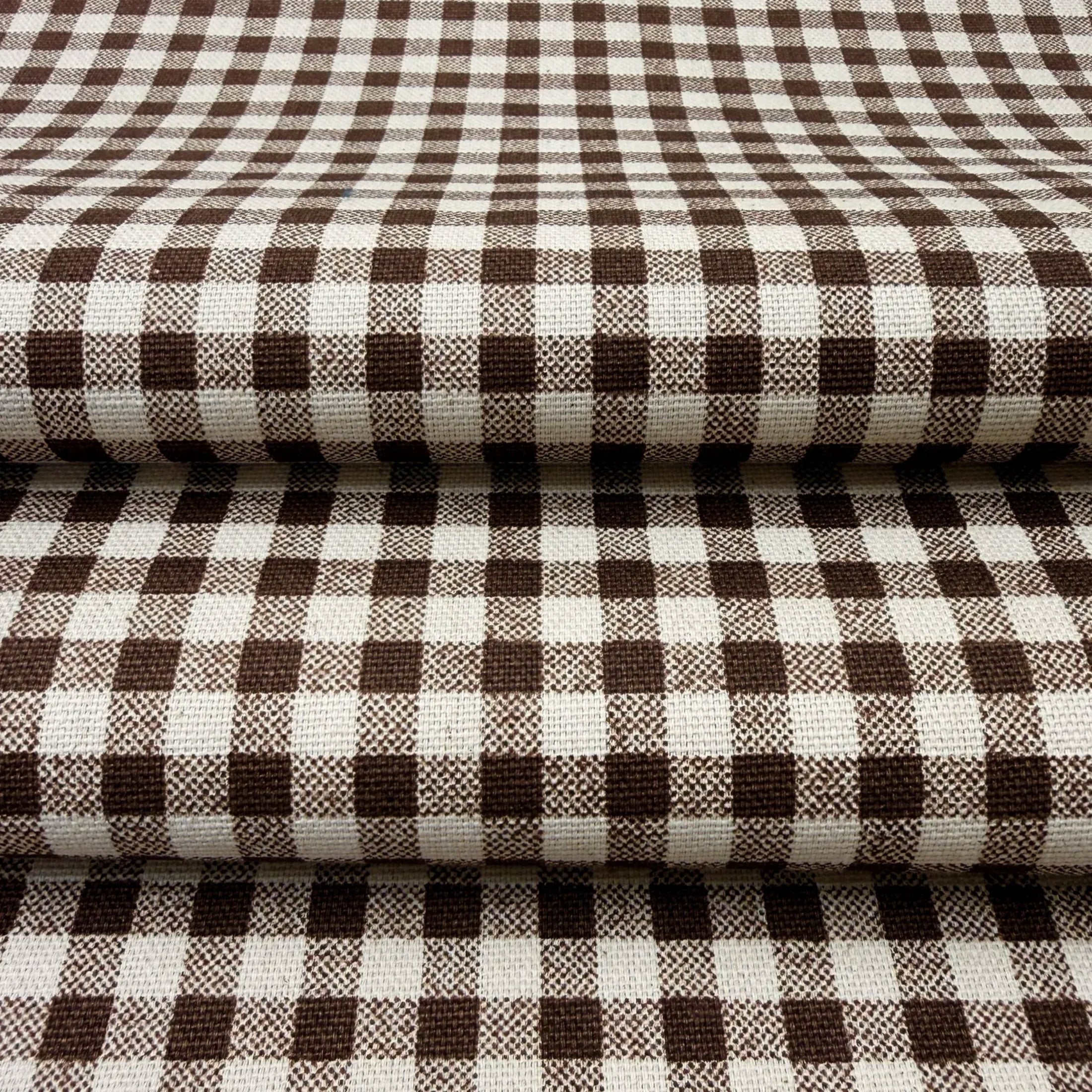 a close-up view of a fabric with a checkered pattern in shades of brown and white.