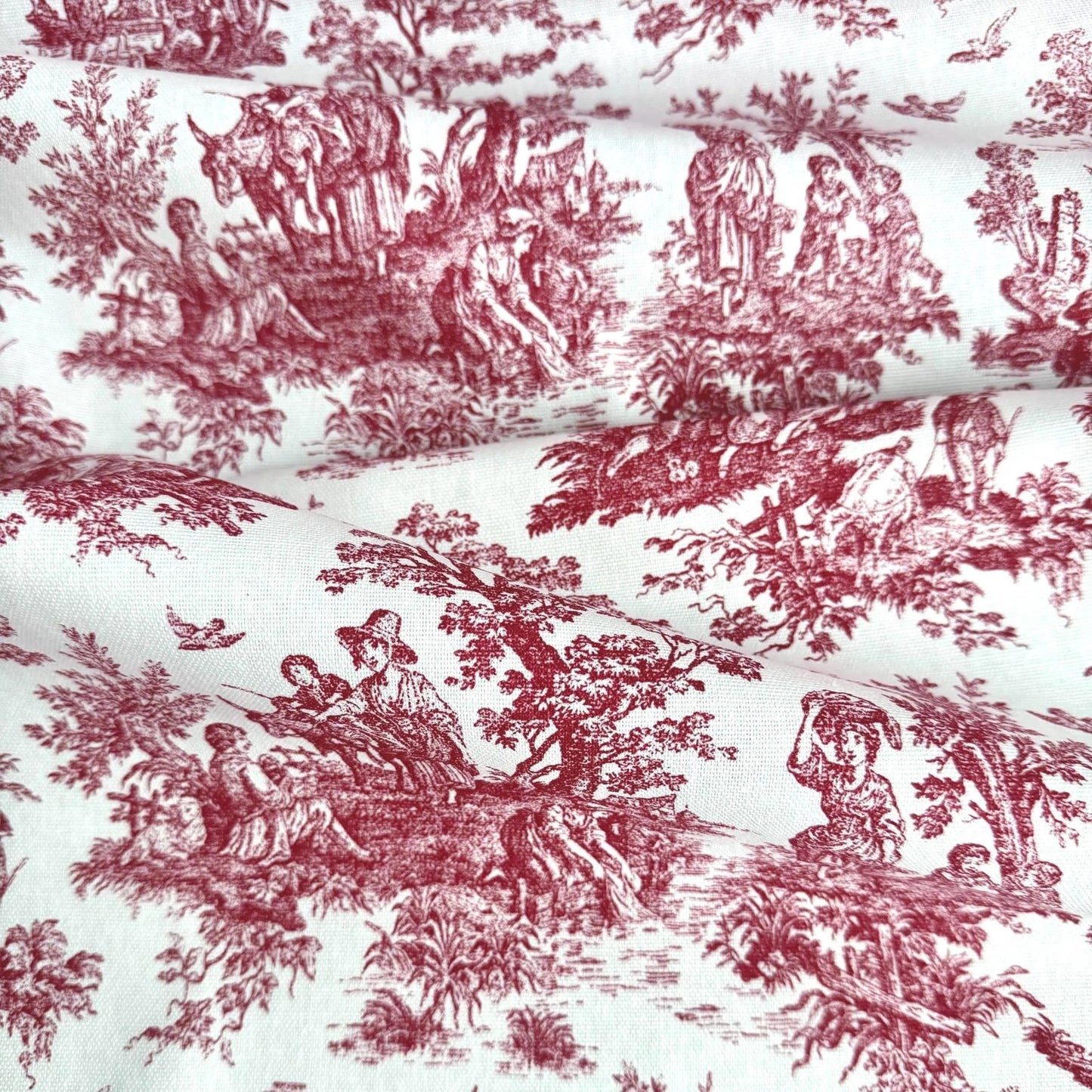 The image is a close-up of a fabric with a repeating pattern of red and white illustrations depicting people and animals in various outdoor scenes.