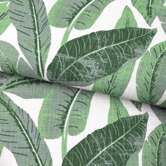 a close-up view of a fabric with a repeating pattern of green palm leaves against a white background.