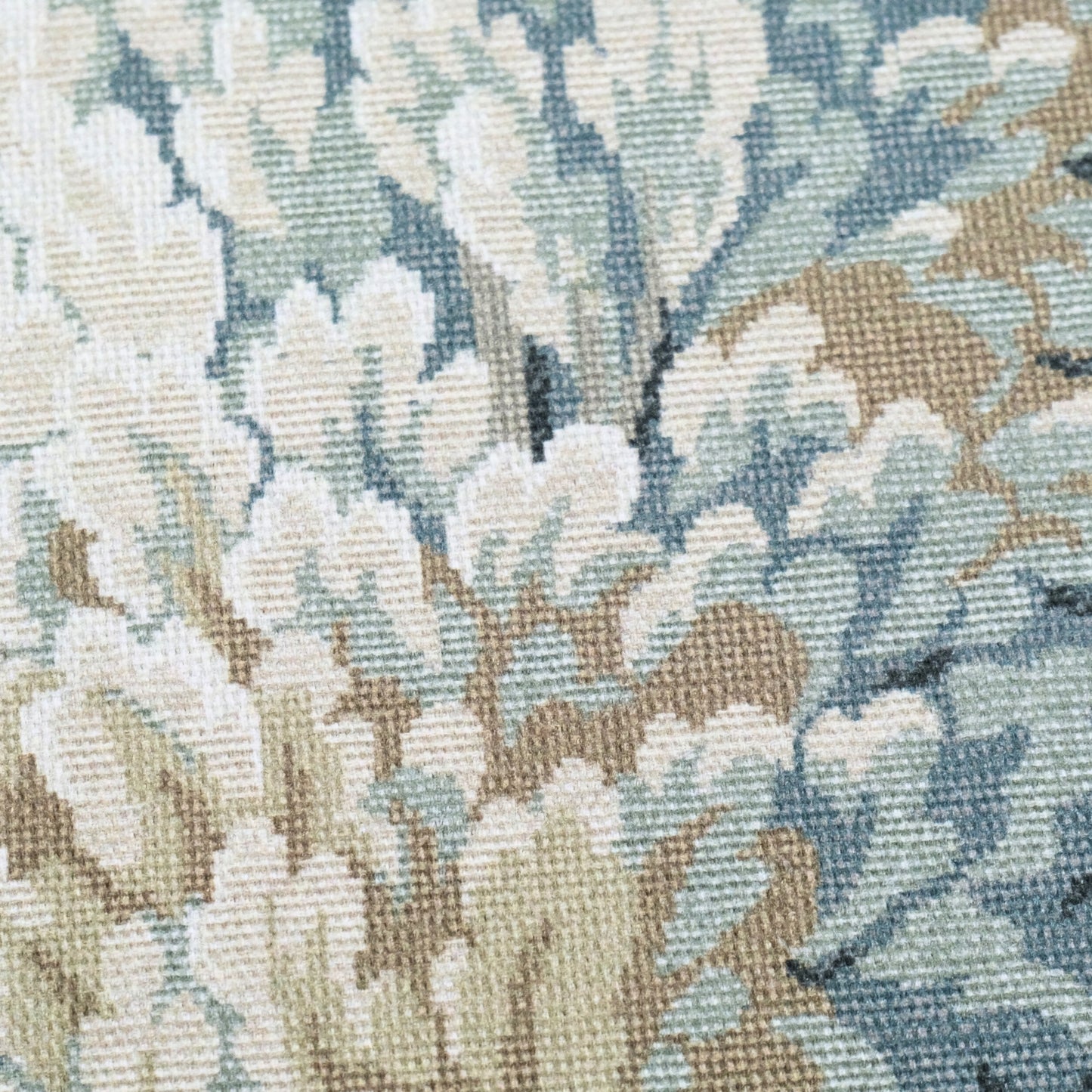 The image is a close-up of a fabric with a floral pattern, featuring a mix of light and dark green and beige colors.