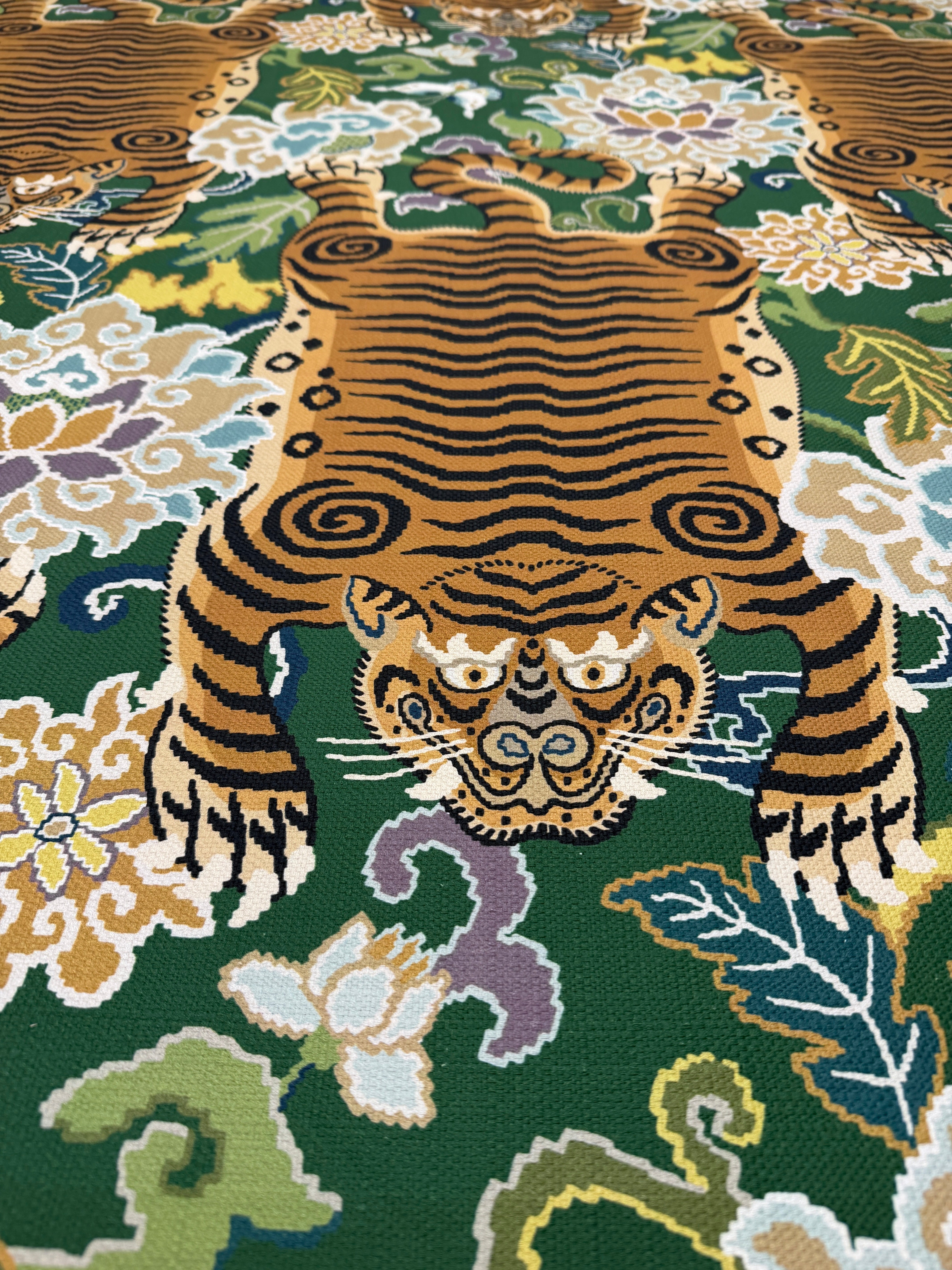 Close-up of the intricate gold tiger and botanical floral motif on a rich emerald green background.