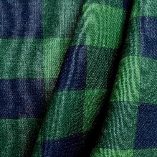 a close-up view of a fabric with a green and blue plaid pattern. The fabric appears to be made of a woven material, with a textured and wrinkled appearance.