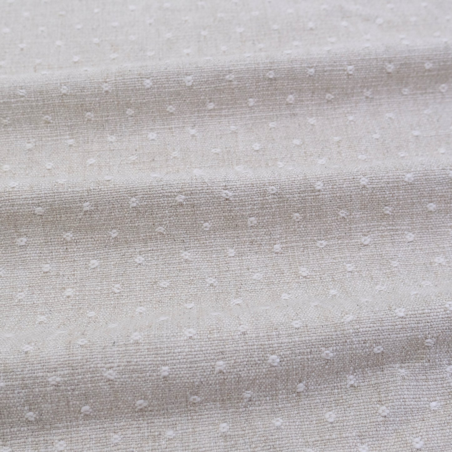 a close-up view of a fabric with small white dots or polka dots, creating a textured and patterned appearance.