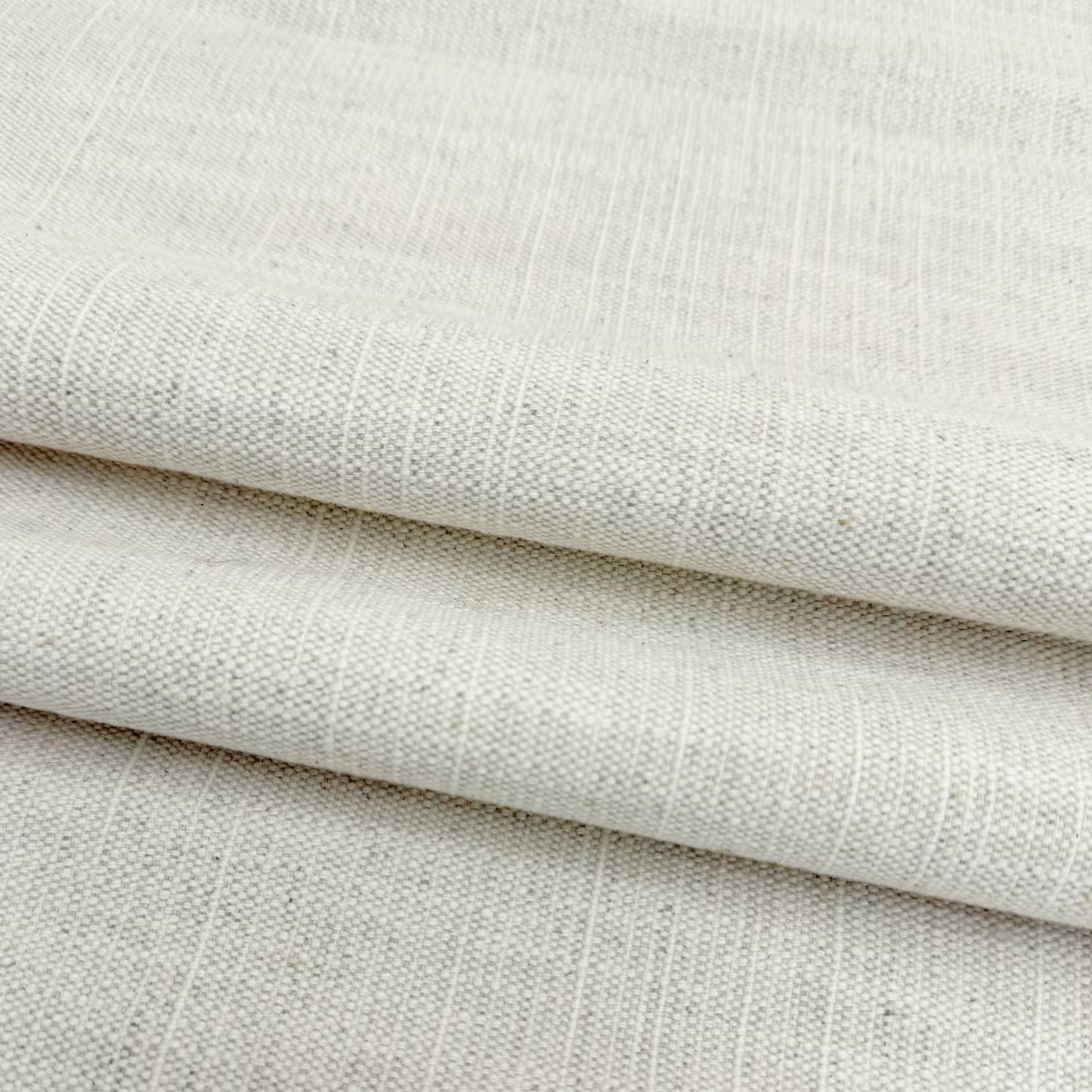 Soft drapes of natural cream slub linen fabric perfect for custom curtains and home decor.