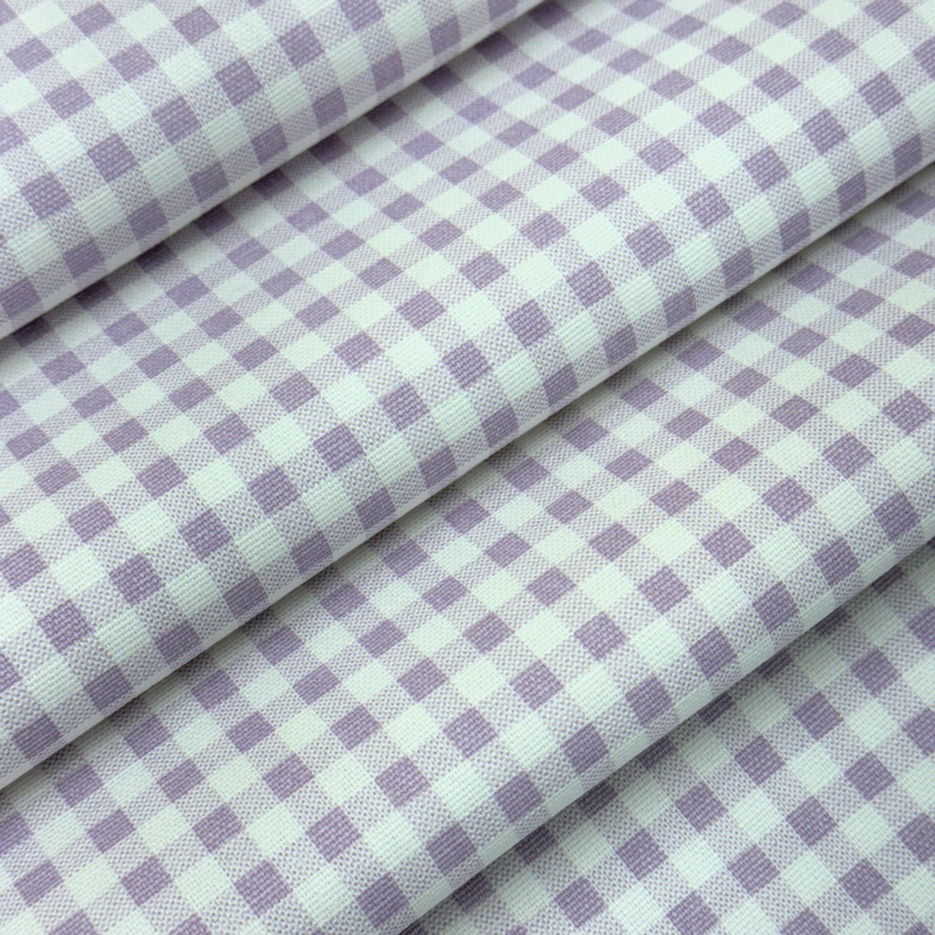 a close-up view of a fabric with a checkered pattern in shades of purple and white.