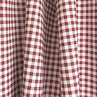 a close-up view of a fabric with a red and white checkered pattern, which appears to be a type of tablecloth or table runner.