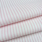a close-up view of a fabric with pink and white striped patterns.