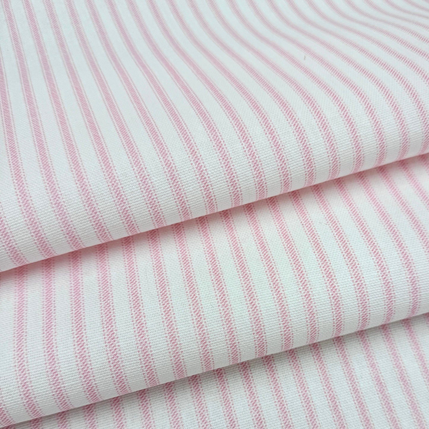 a close-up view of a fabric with pink and white striped patterns.