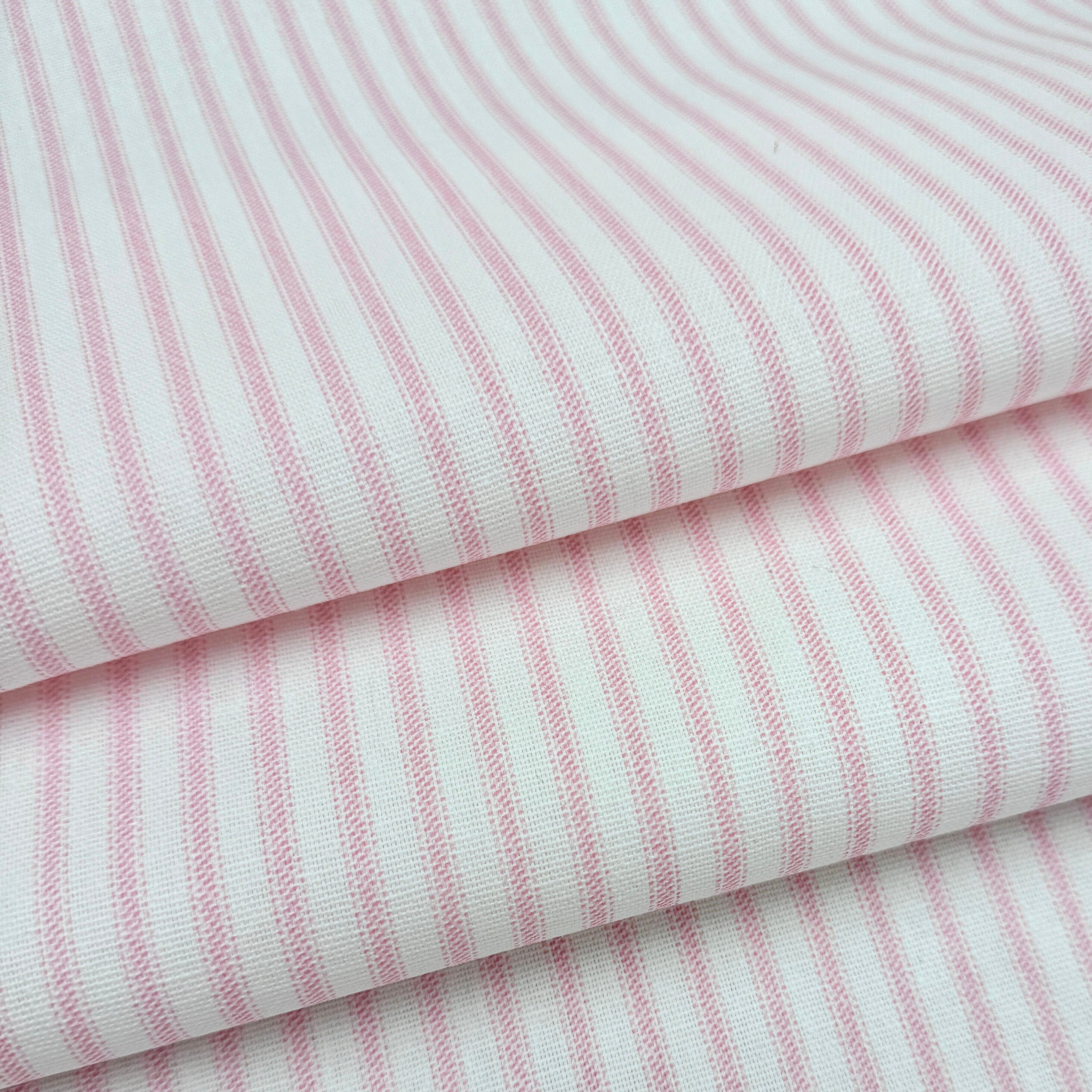 a close-up view of a fabric with pink and white striped patterns.