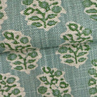a close-up view of a fabric with a repeating pattern of green and white leaf-like designs.