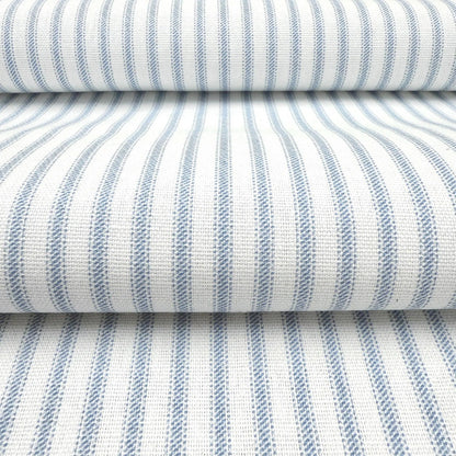 a close-up view of a fabric with a striped pattern in shades of blue and white. The fabric appears to be folded or rolled up, creating a layered effect.