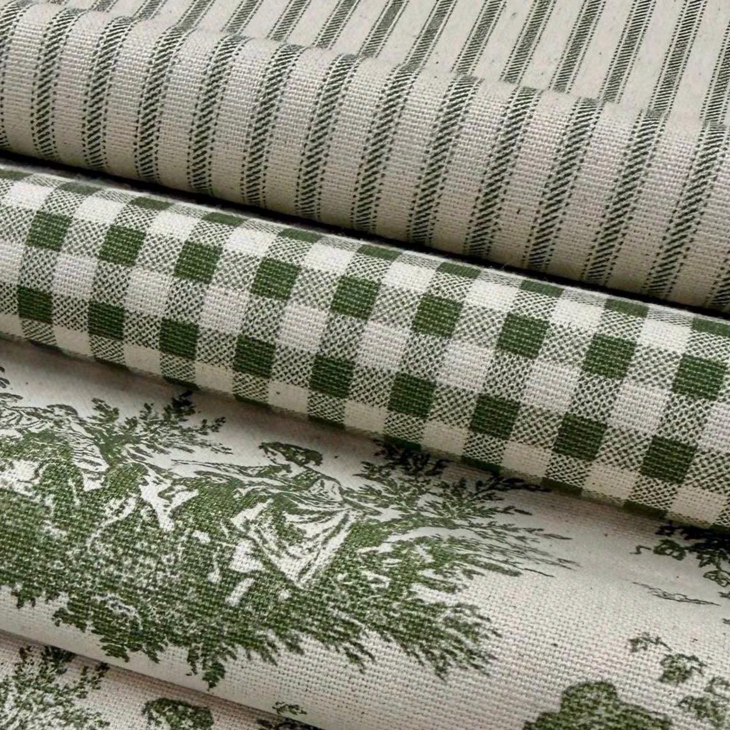 a close-up view of a stack of fabric rolls with a green and white checkered pattern.