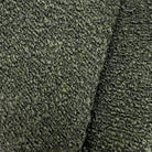 a close-up view of a textured fabric with a dark green or black color. The fabric appears to be made of a tightly woven material, giving it a distinctive and intricate appearance.