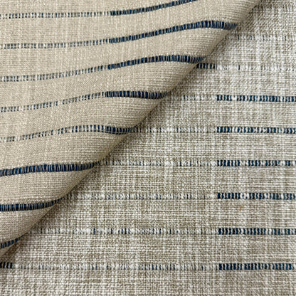 a close-up view of a fabric with a striped pattern in shades of beige and blue. The fabric appears to be made of a woven material, with the stripes running across the entire surface.