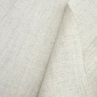 Close-up of oatmeal-colored textured linen material highlighting the natural organic fiber weave.