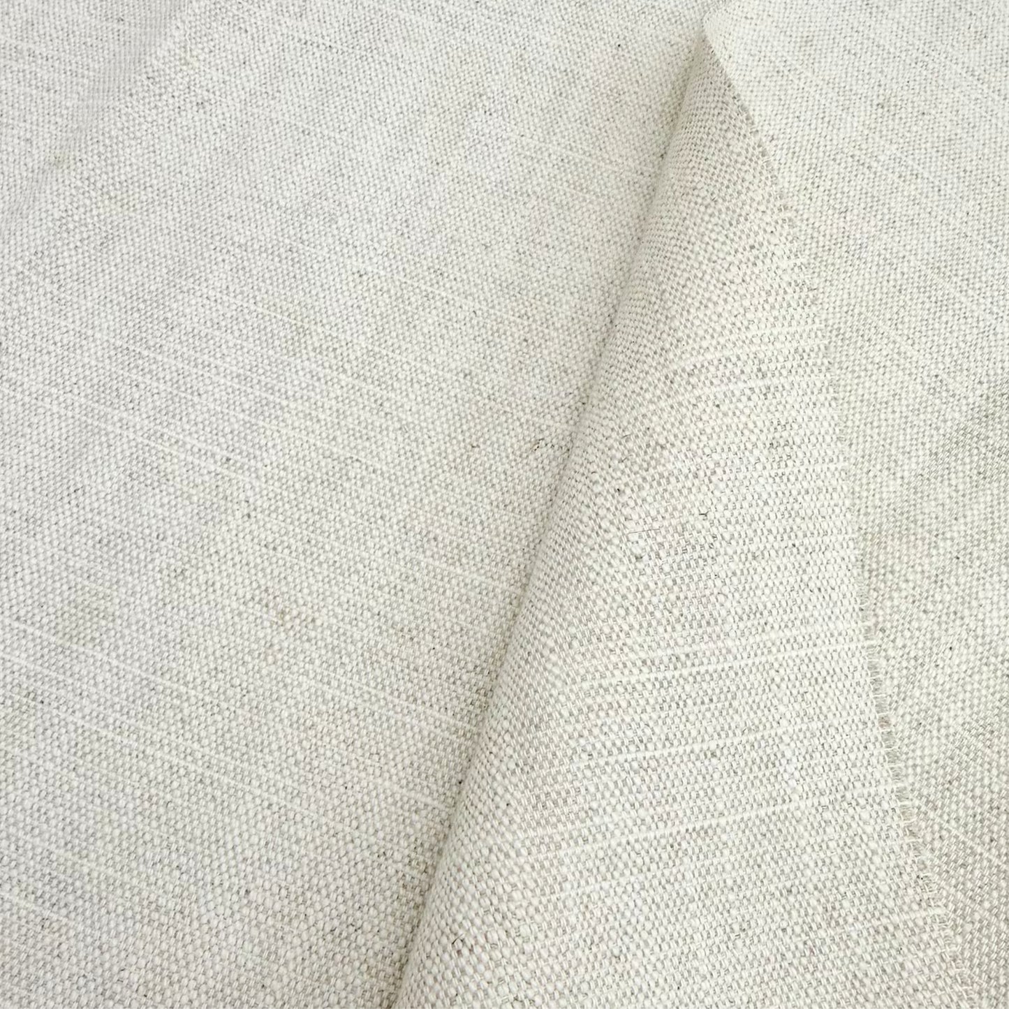 Close-up of oatmeal-colored textured linen material highlighting the natural organic fiber weave.