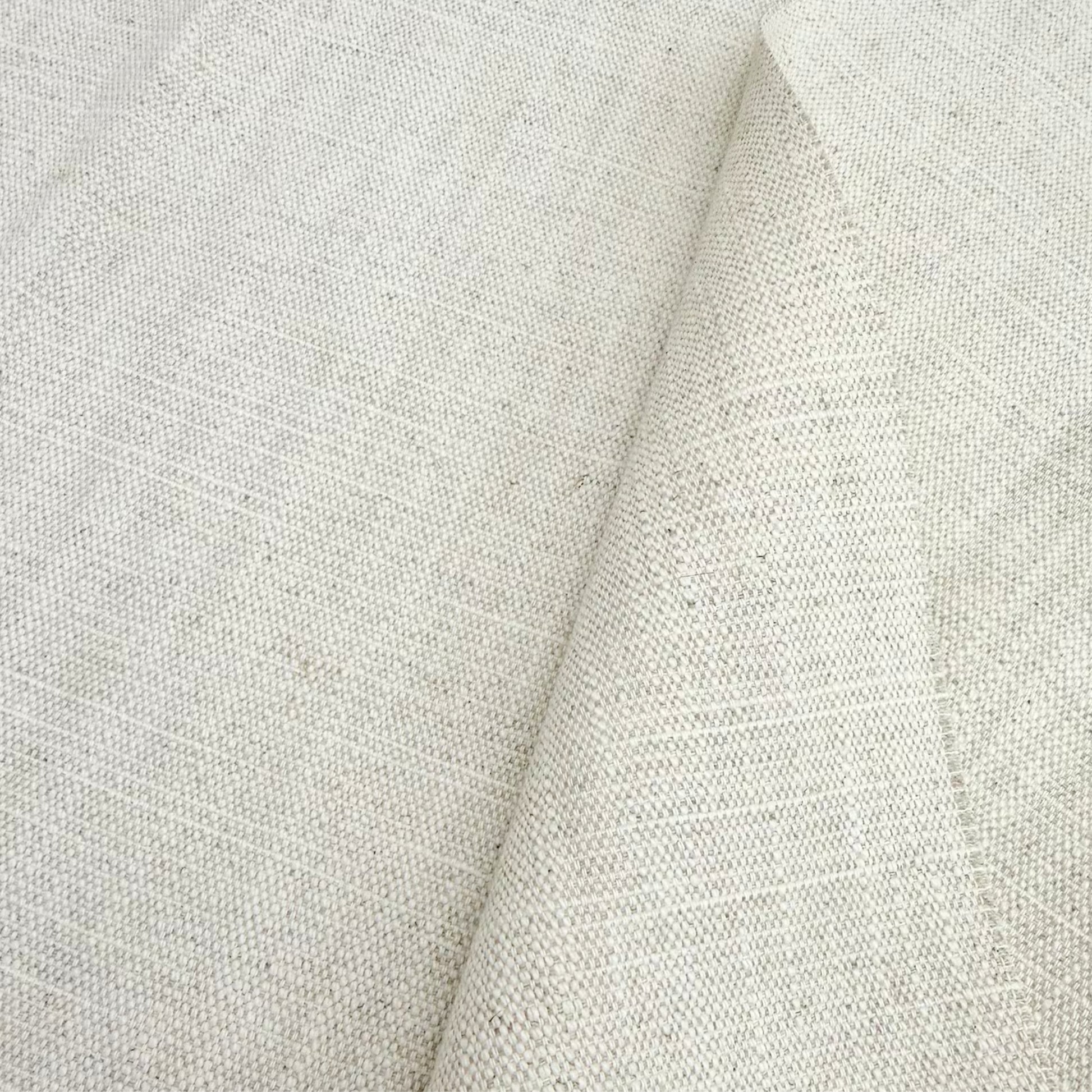Close-up of oatmeal-colored textured linen material highlighting the natural organic fiber weave.