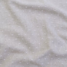a close-up view of a fabric with small white dots or polka dots, creating a textured and patterned appearance.