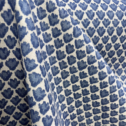 Blue and cream small scale block print fabric draped to show repeating pattern and texture