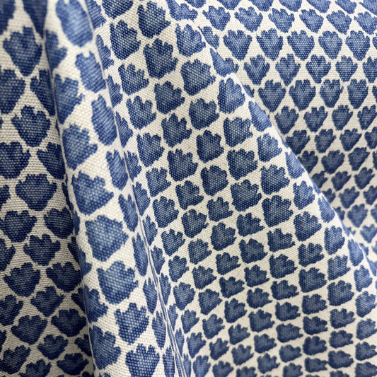 Blue and cream small scale block print fabric draped to show repeating pattern and texture