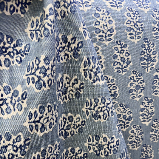 Light blue and cream block print fabric with floral medallion pattern draped to show texture