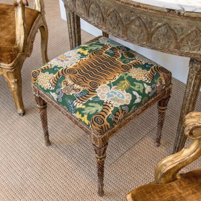 a decorative chair with a vibrant tiger print cushion, placed on a carpeted floor.