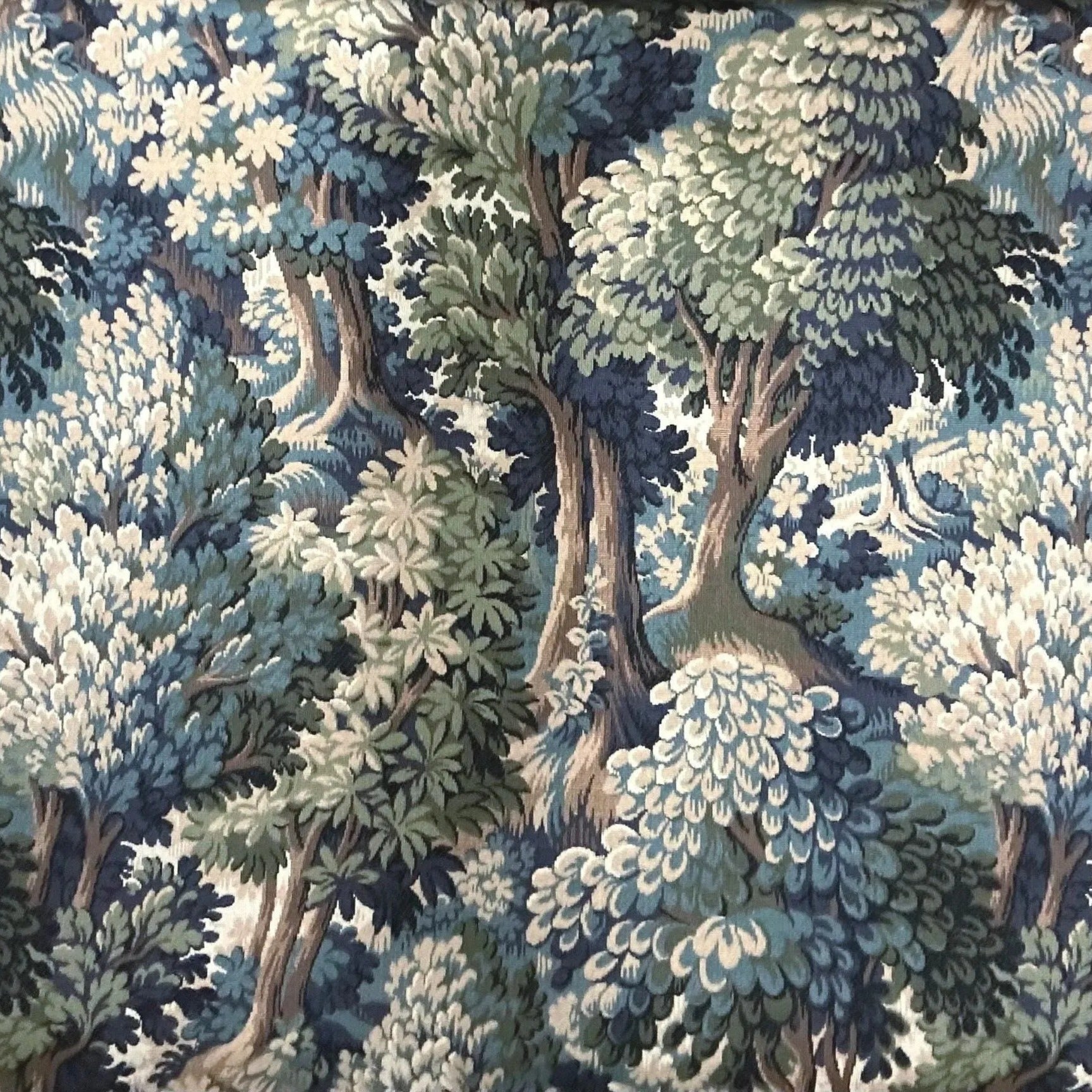 The image is a detailed tapestry or fabric with a lush, forest-like scene. It features a variety of trees and foliage in shades of green, blue, and white, creating a sense of depth and complexity. The overall composition is intricate and visually striking, with the intricate patterns and textures of the fabric or tapestry drawing the viewer's attention.