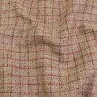 a close-up view of a fabric with a checkered pattern in shades of beige and red.