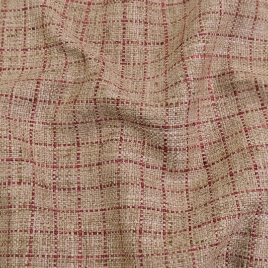 a close-up view of a fabric with a checkered pattern in shades of beige and red.