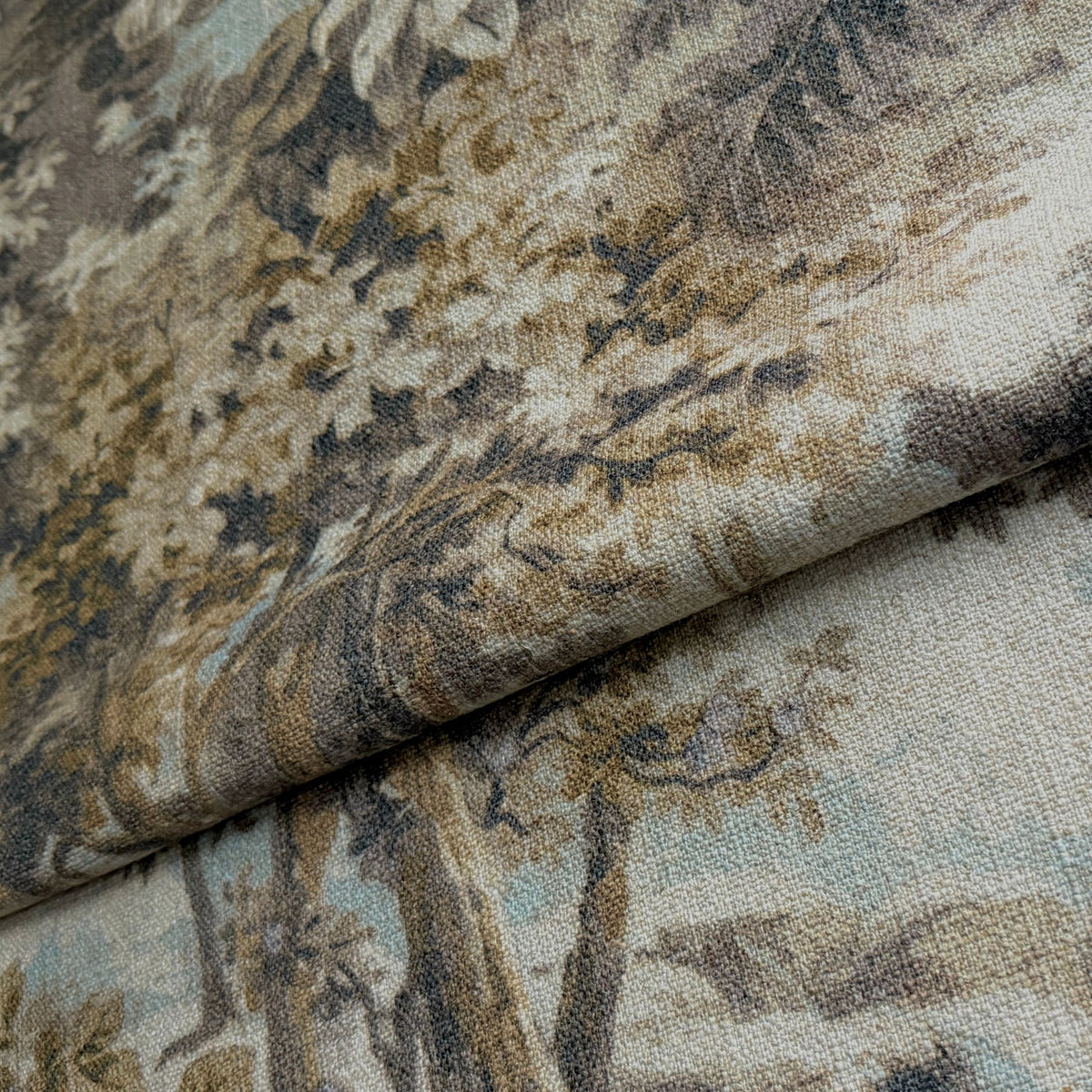 Arcadian Fog toile fabric folded to show the pastoral print and pale aqua undertone