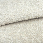 A close-up image of a textured fabric, likely a white or cream-colored material, with a slightly curled or folded appearance.