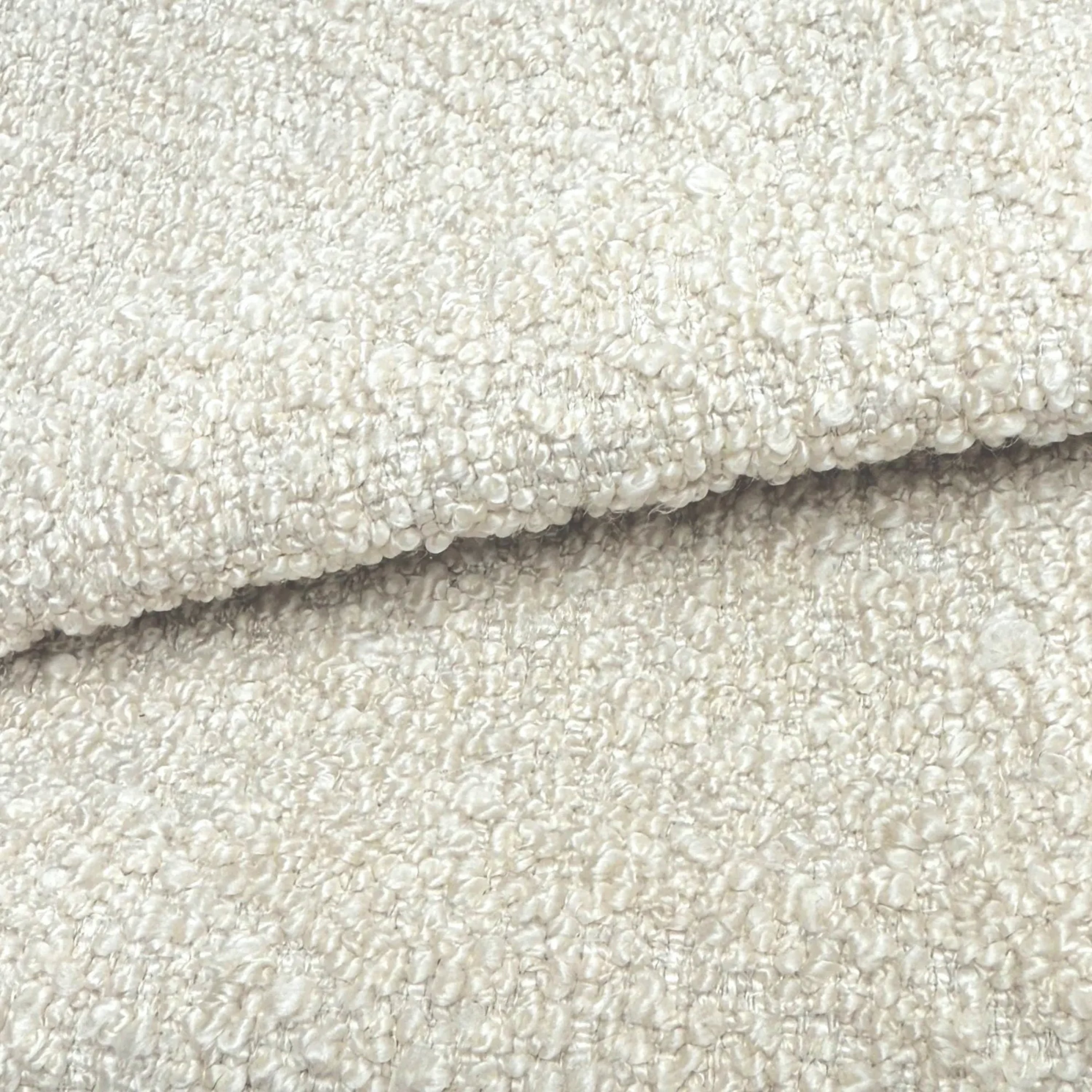 A close-up image of a textured fabric, likely a white or cream-colored material, with a slightly curled or folded appearance.