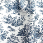 The image is a close-up of a fabric with a repeating pattern of black and white illustrations depicting people in various activities, such as sitting, standing, and interacting with nature.