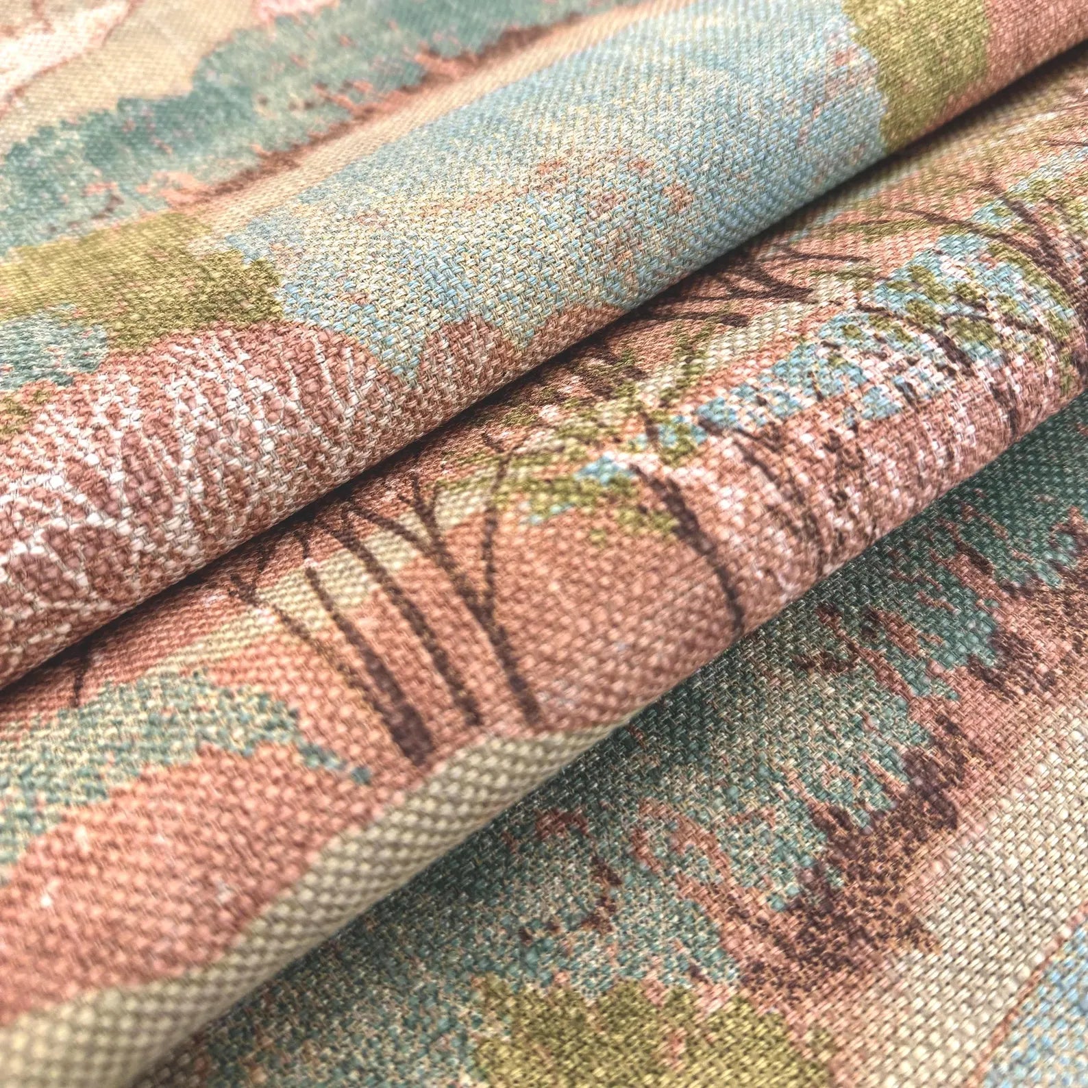 Stacked layers of Pink Scenic Forest Landscape Fabric showing the natural folds and rich color palette.