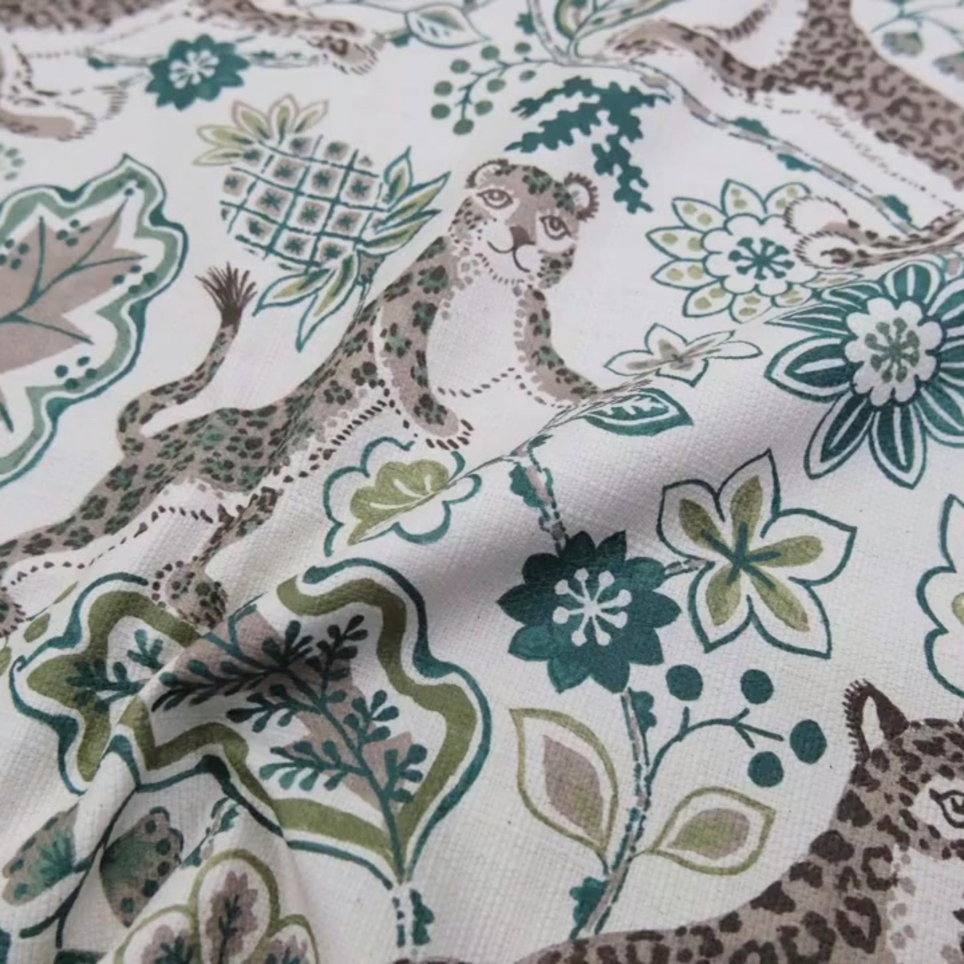 a close-up view of a fabric with a repeating pattern of leopard and floral designs.