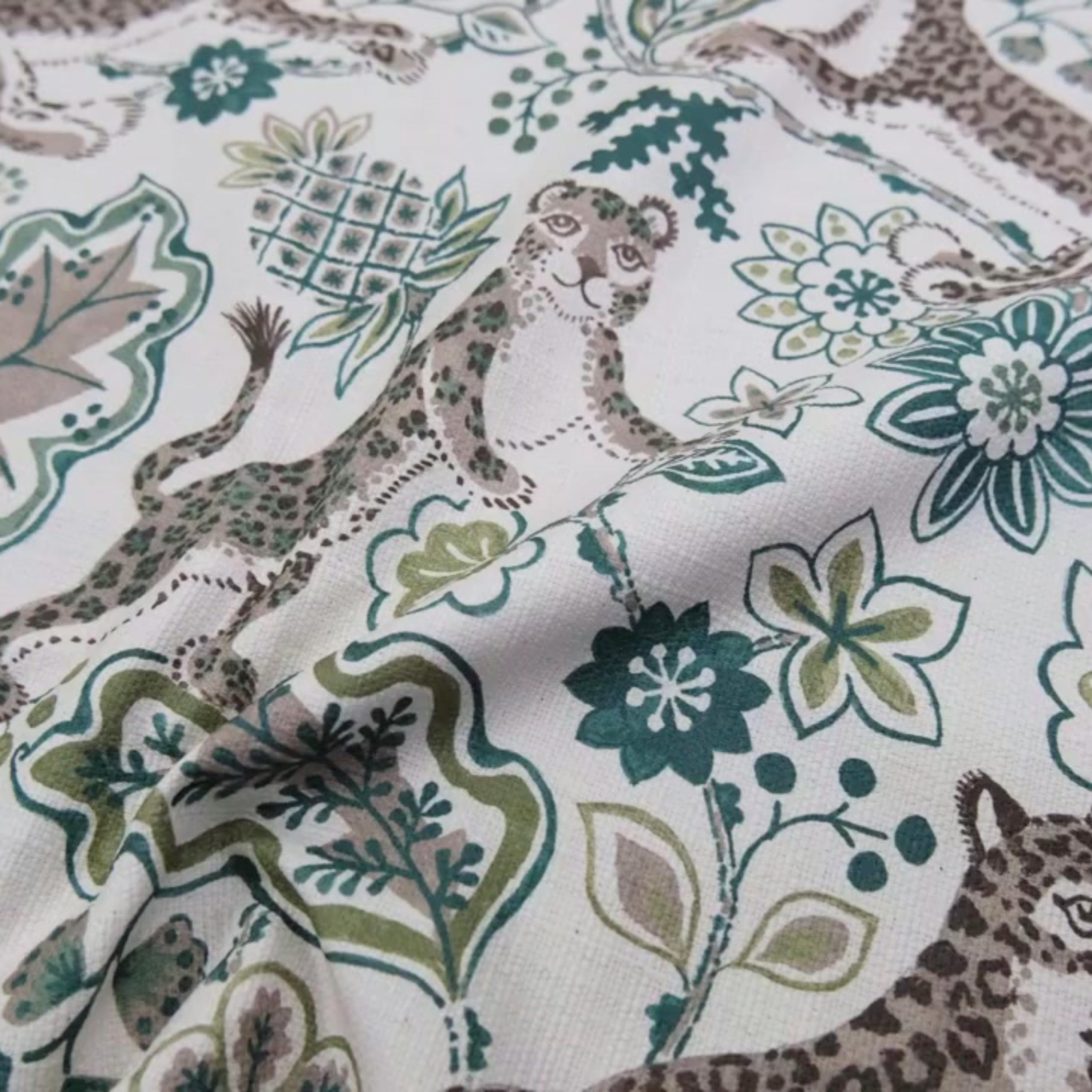a close-up view of a fabric with a repeating pattern of leopard and floral designs.