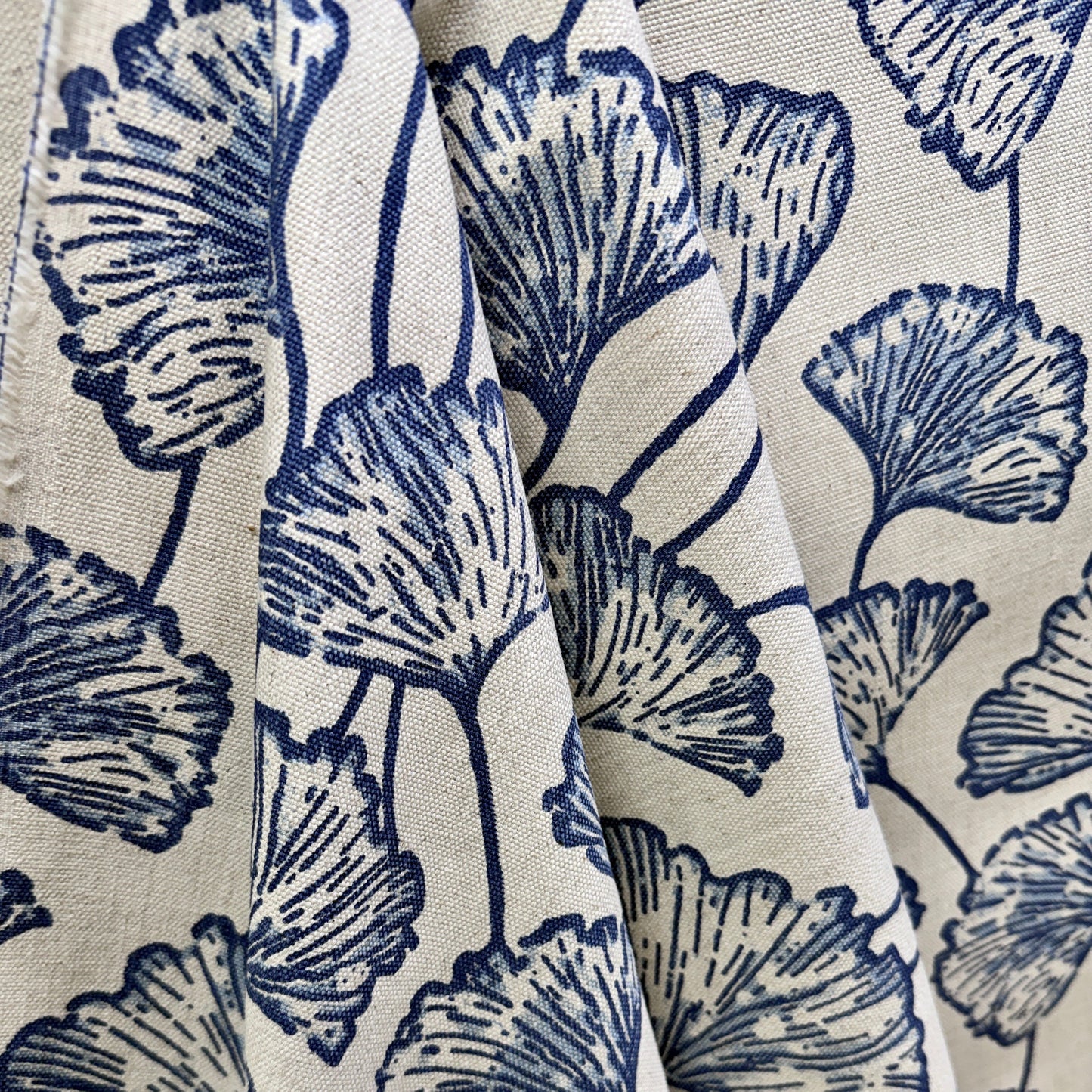 Blue and cream ginkgo leaf fabric draped to show large scale botanical pattern and texture
