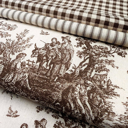 a close-up view of a fabric with a detailed brown and white pattern depicting a pastoral scene with people, animals, and trees.