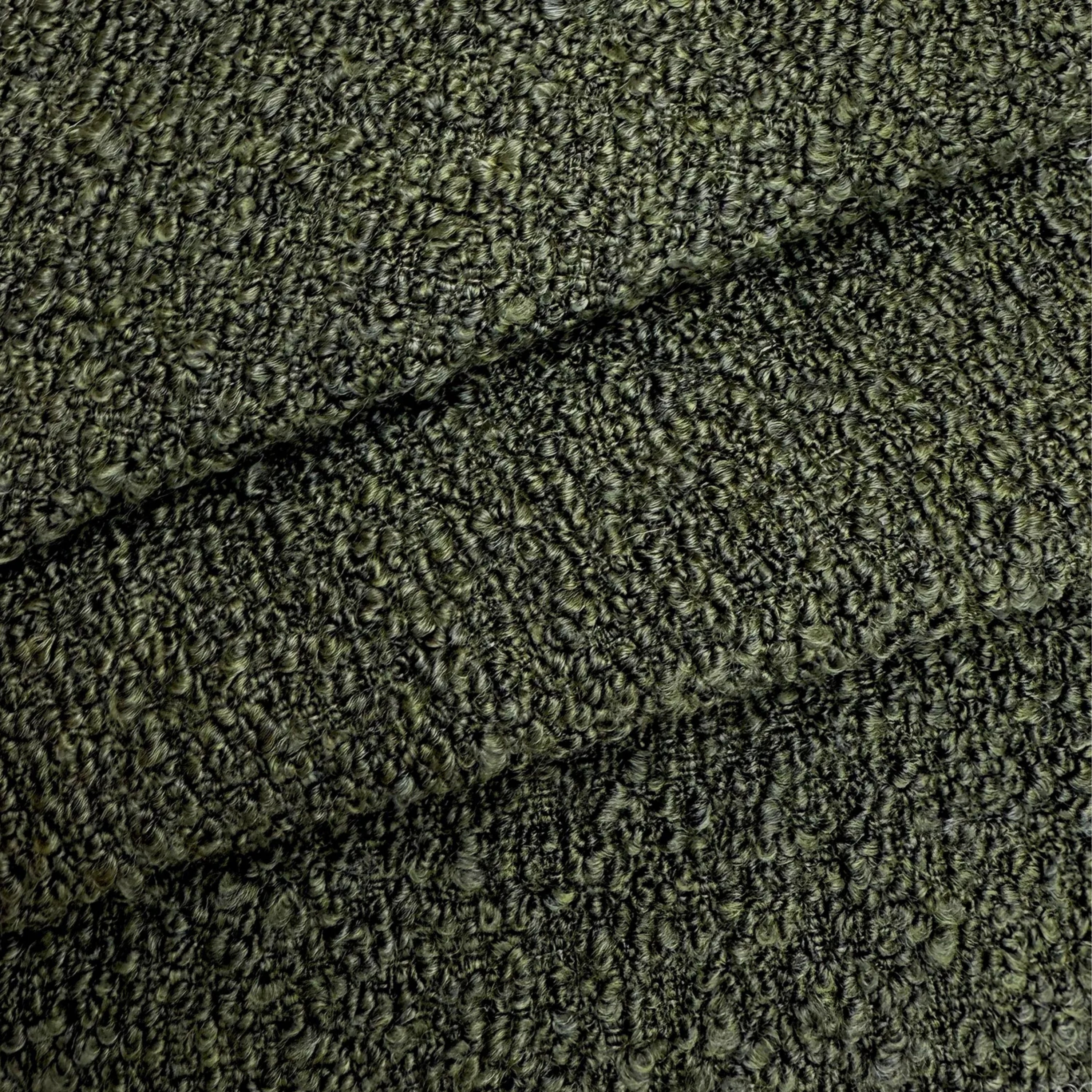 a close-up view of a textured fabric with a dark green or black color. The fabric appears to be made of a tightly woven material, giving it a distinctive and intricate appearance.