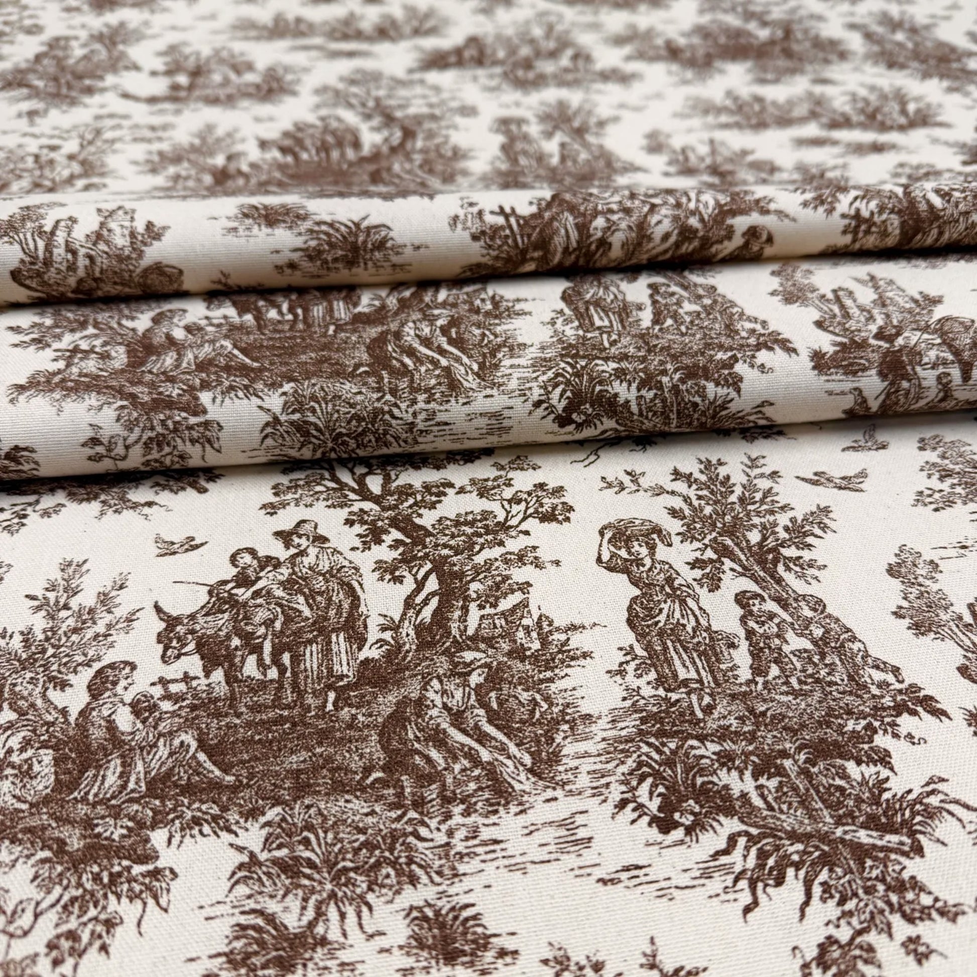 a close-up view of a fabric with a repeating brown and white pattern depicting various scenes, including people, animals, and natural elements. The pattern is detailed and intricate, showcasing the craftsmanship and artistry of the design.