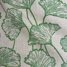 a close-up view of a fabric with a repeating pattern of green leaves or flowers. The pattern is intricate and detailed, with the leaves or flowers appearing to be made of a soft, textured material. The fabric has a white background, which contrasts with the green leaves and makes them stand out. The leaves are arranged in a way that creates a sense of depth and dimension, giving the fabric a three-dimensional appearance.