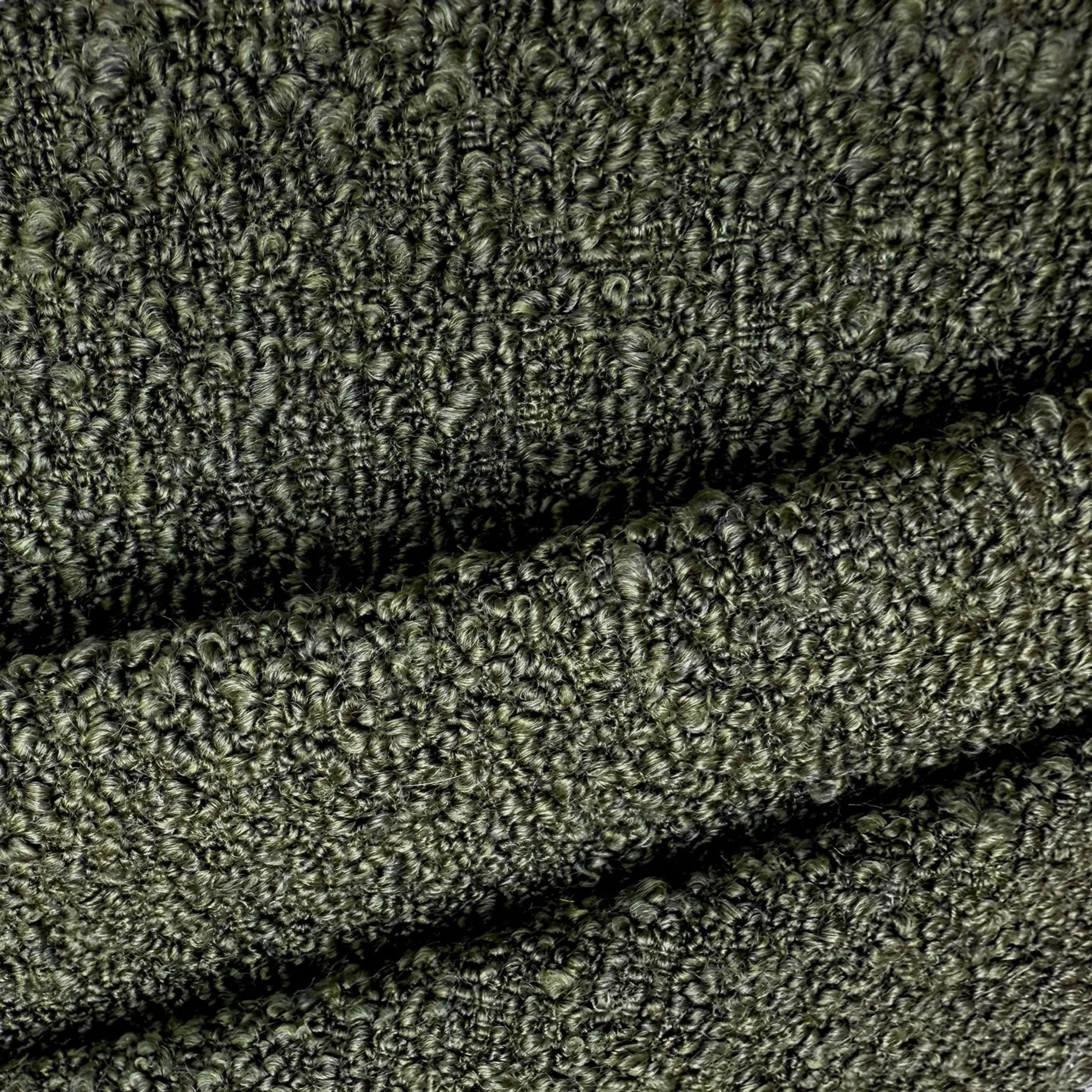 a close-up view of a textured fabric, possibly a piece of clothing or a textile. The fabric appears to be made of a material with a fuzzy, knitted or crocheted texture, giving it a somewhat rough and uneven appearance. The image does not contain any discernible objects or actions, and there are no specific actions or movements depicted. The focus is on the fabric's texture and pattern.