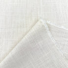 a close-up view of a white fabric with a criss-cross pattern, folded over itself to create a crease.