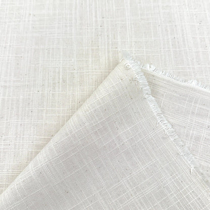 a close-up view of a white fabric with a criss-cross pattern, folded over itself to create a crease.